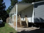 patio cover along the side of a mobile home with a deck and post